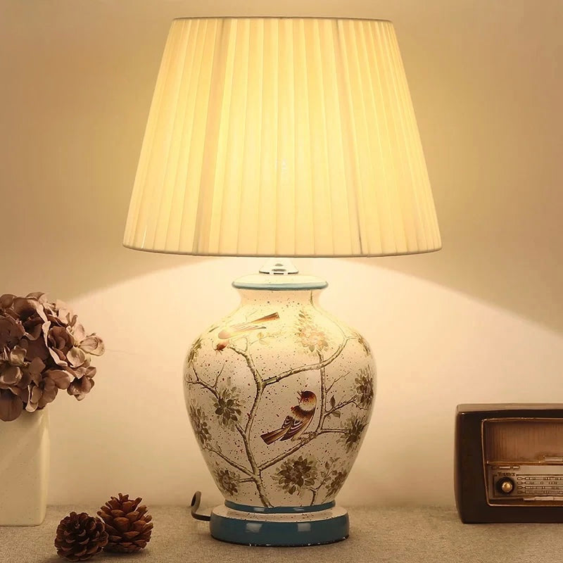 Crackled cream ceramic table lamp with bird and branch artwork and pleated shade