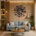 A styled living room featuring a light blue fabric sofa, a round wooden coffee table, and a large black metal sun wall art piece mounted on a textured beige wall.
