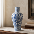 Blue and white floral ceramic vase on a wooden surface with a neutral background