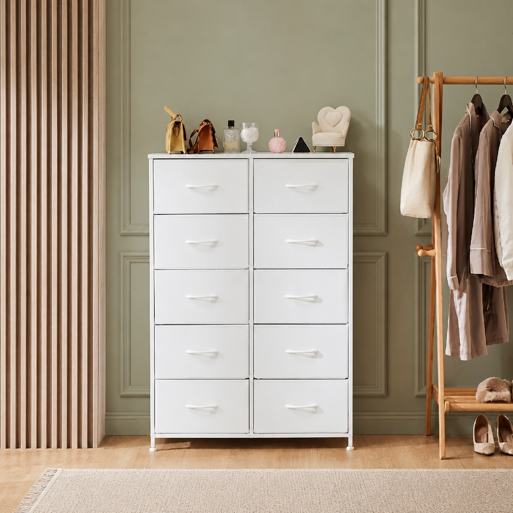 A white 10-drawer dresser with silver handles stands in a styled room with sage-green panelled walls, a wooden slat screen, and a clothing rack holding garments.