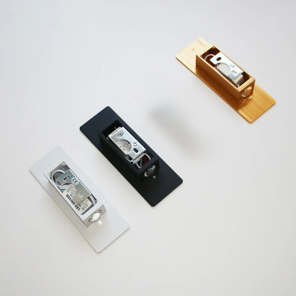 Rear view of wall lights in white, black, and gold finishes, showing mounting structure