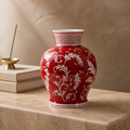 Red vase with white floral patterns on a wooden surface