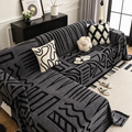 Dark Grey tribal print sofa cover on L-shaped couch with cushions