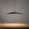 Black minimalist pendant light with wide, low-profile shade above a round wooden table