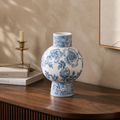 Blue and white floral ceramic vase on a wooden surface with a neutral background