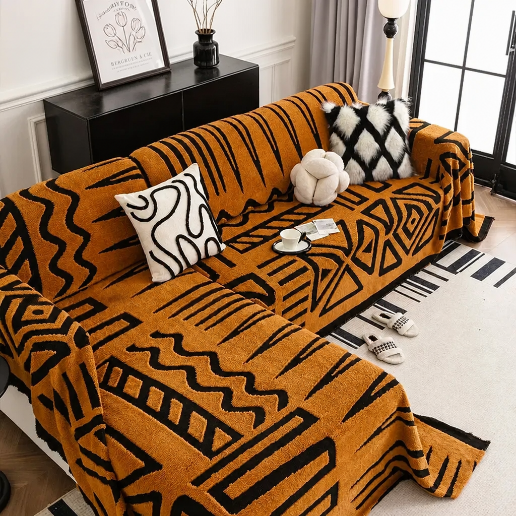 Rust orange tribal print sofa cover on L-shaped couch with cushions
