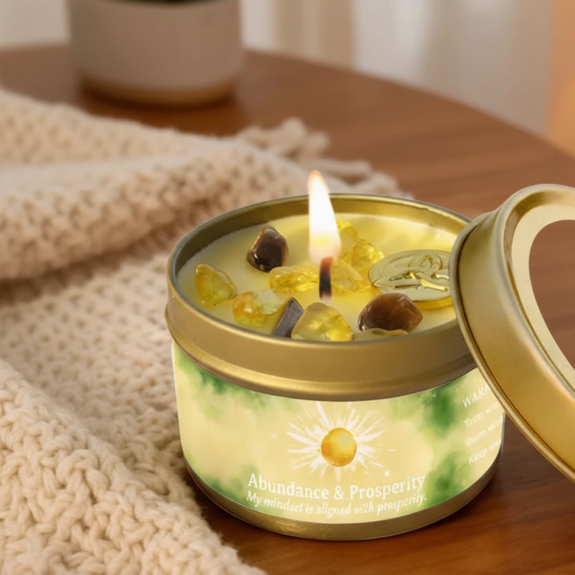 Abundance and prosperity candle in a gold tin with 'EVODUCK' branding on a wooden surface.
