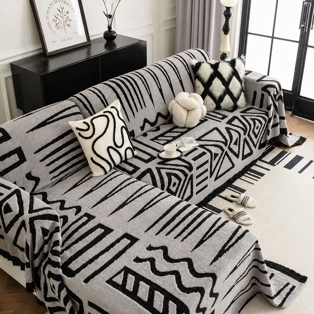 Light grey tribal print sofa cover on L-shaped couch with cushions