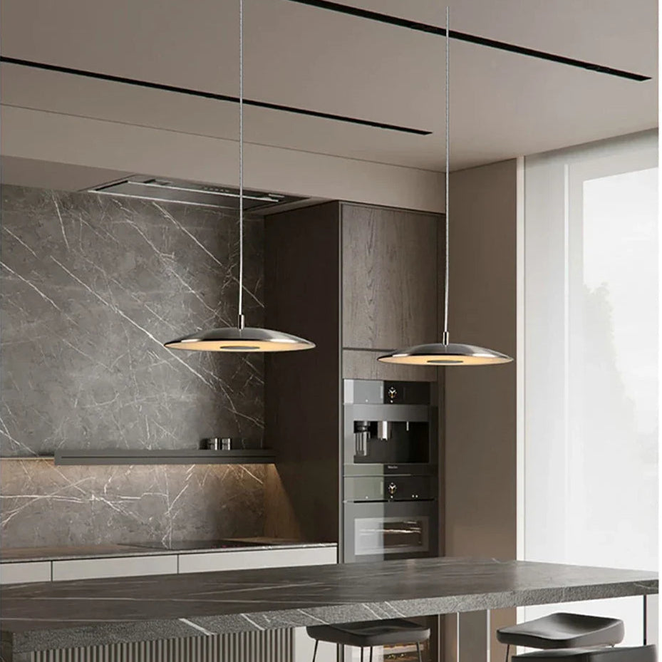 Modern kitchen with marble countertops, pendant lights, and bar stools.