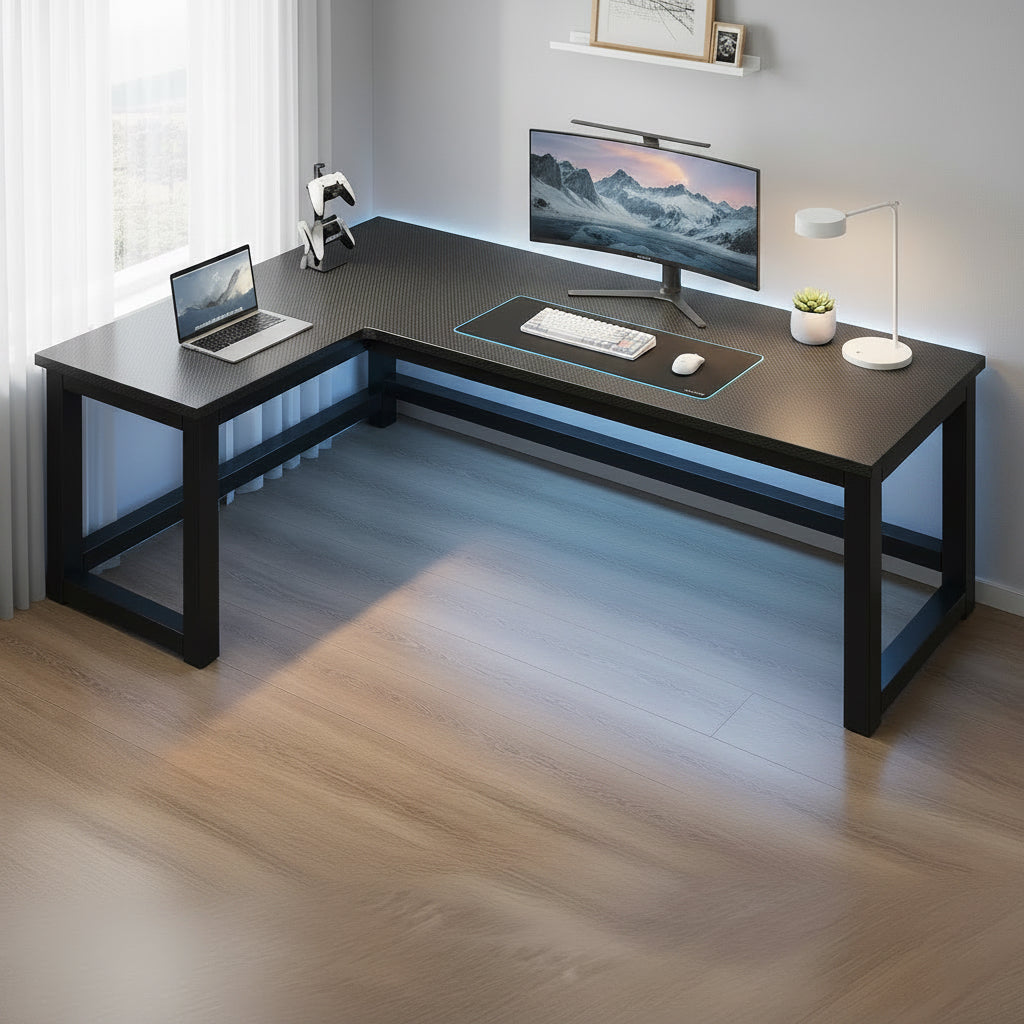 Black L-shaped desk with measurements and computer setup in a room.