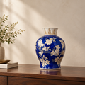 Blue porcelain vase with flared patterned neck and floral design, 23cm tall.
