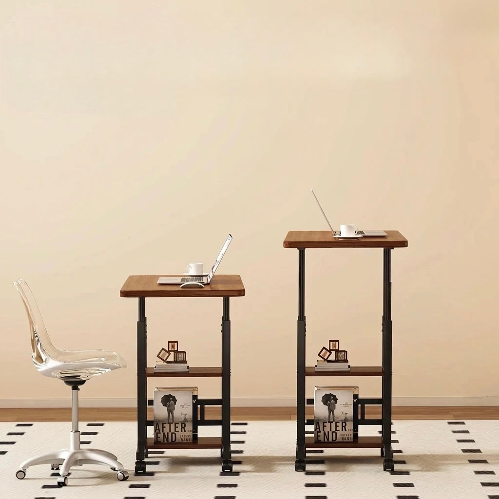 Two adjustable standing desks with wood-look tops and black metal frames are shown in a minimalist room setting. One desk is shorter with a laptop and cup on top, and the other is taller with a laptop and cup on top.