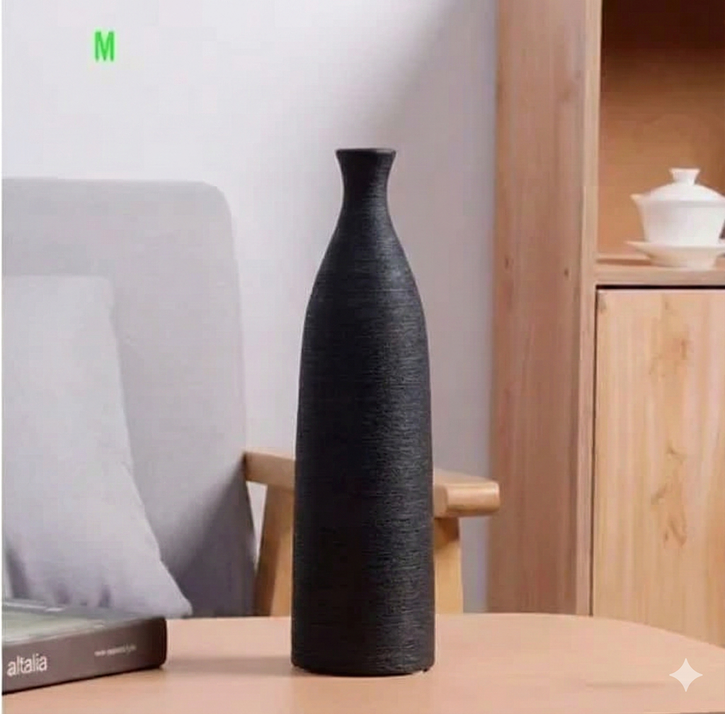 Black textured vase on a wooden table with a blurred background