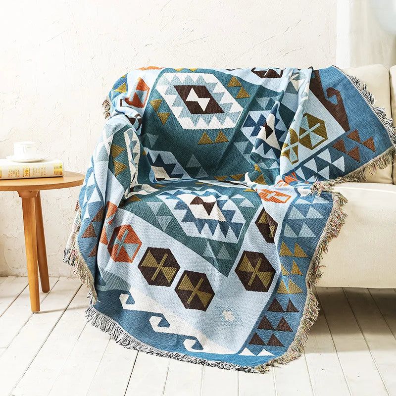 Indigo Mosaic woven throw draped over a cream armchair