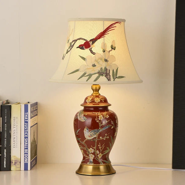 Decorative table lamp with floral and bird design on a beige background