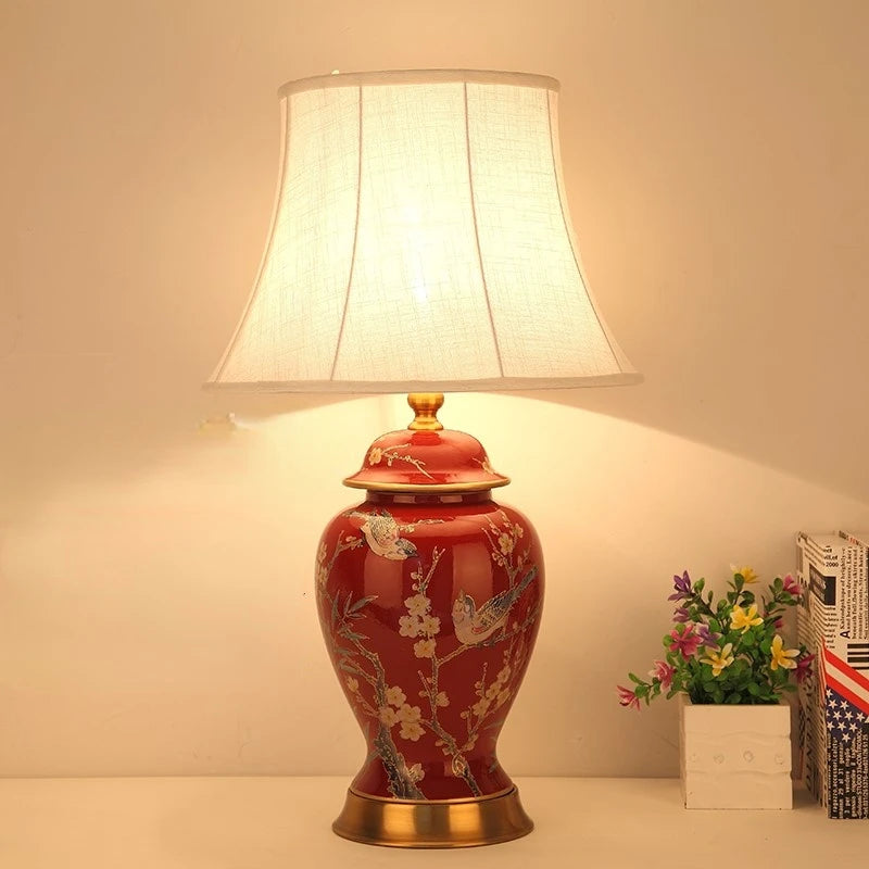 Decorative table lamp with floral design on a white surface.