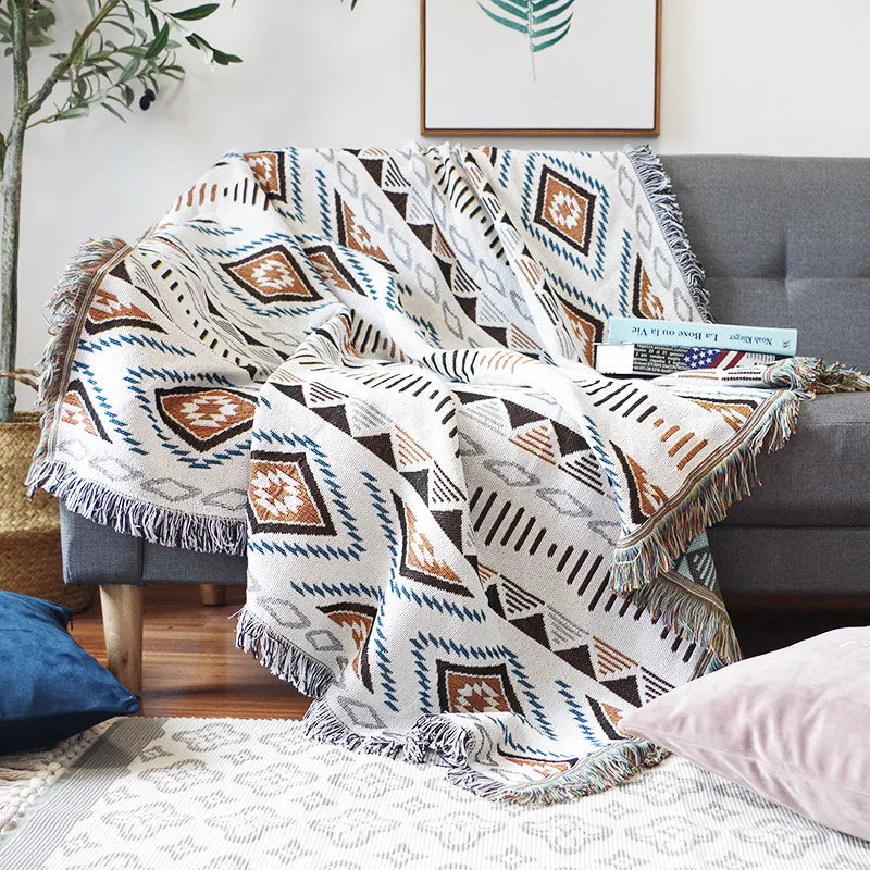 Gray armchair with a patterned blanket draped over it in a living room setting.