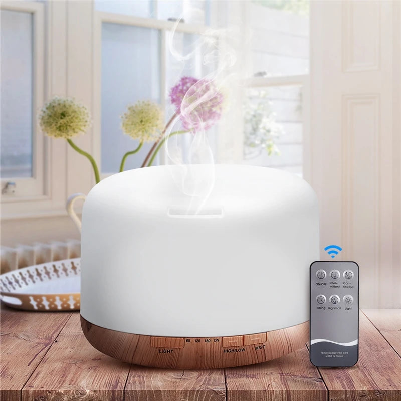 White essential oil diffuser with wooden base on a wooden table, accompanied by a remote control.