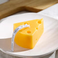 Cheese-shaped candle with a label on a white plate