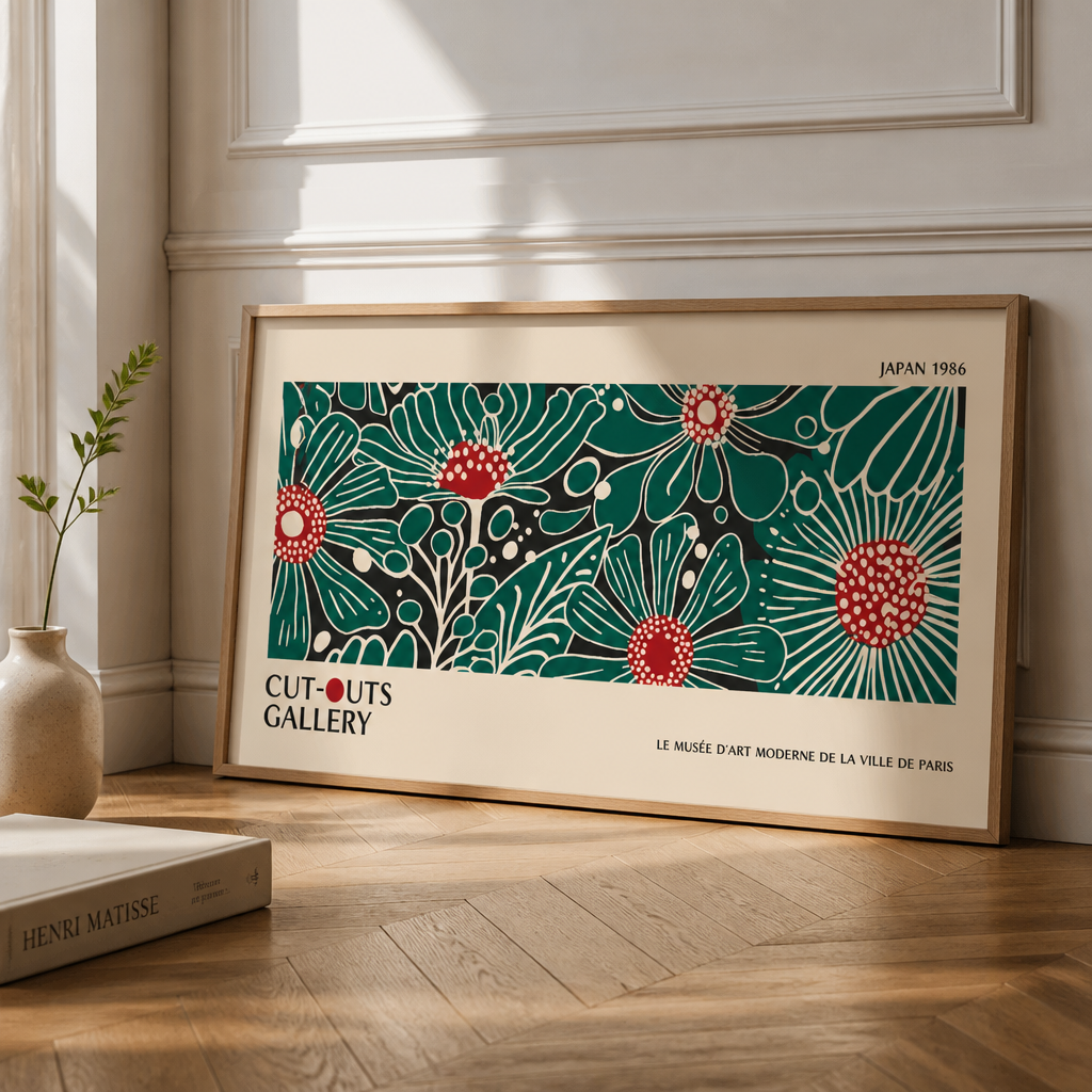Wide floral gallery poster print with green and red botanical artwork leaning against a wall in a framed room setting.