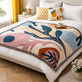 Abstract colour block throw blanket with fringe detail on a bed