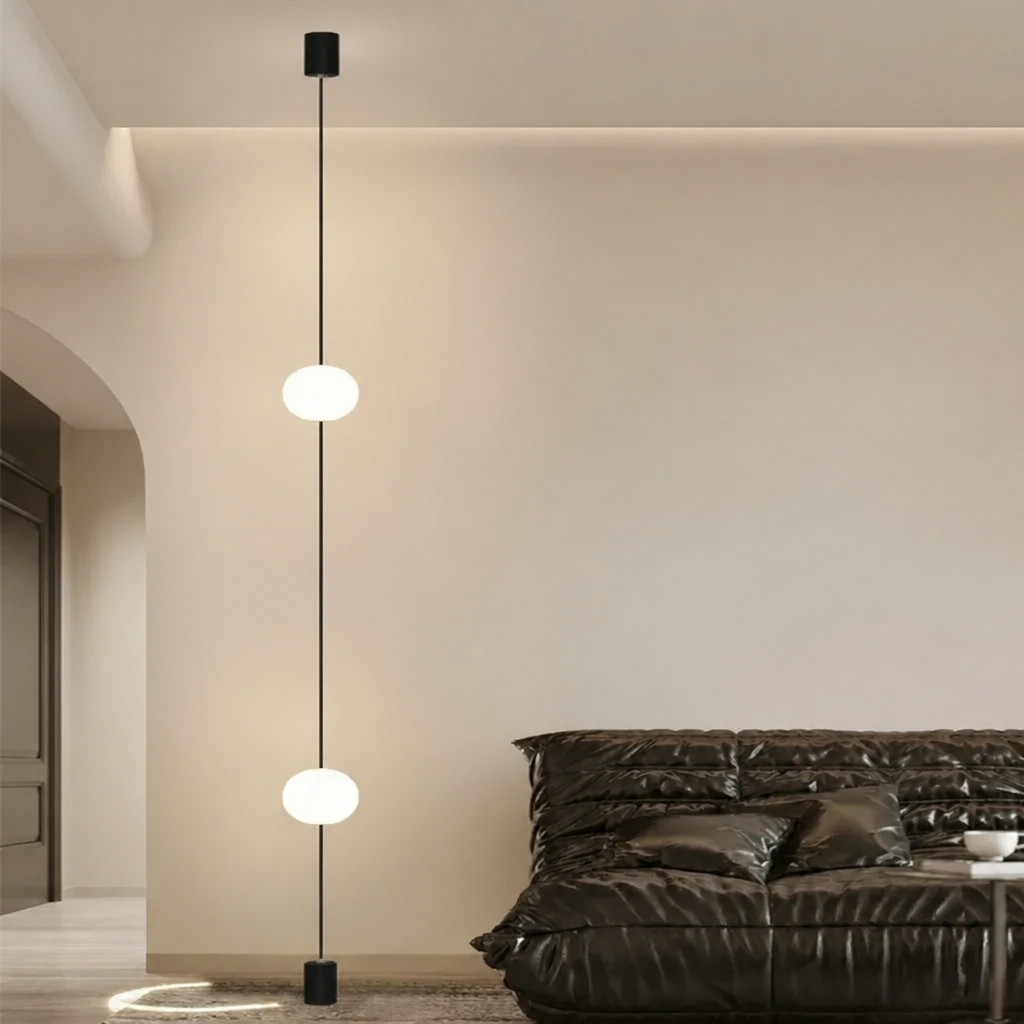 Minimalist living room with 2-head floor-to-ceiling globe pendant light against white wall