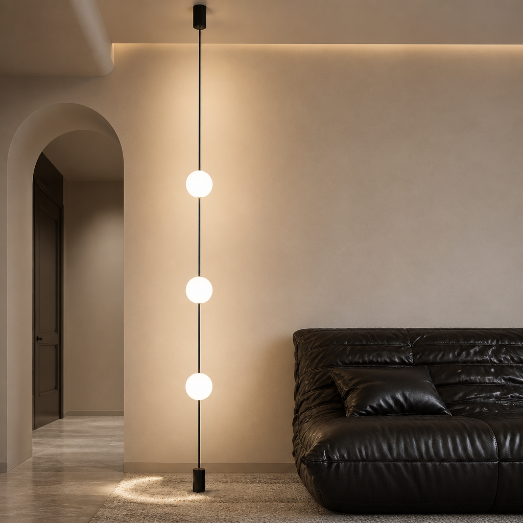 Contemporary lounge space with 3-head floor-to-ceiling LED globe light next to a rounded white armchair