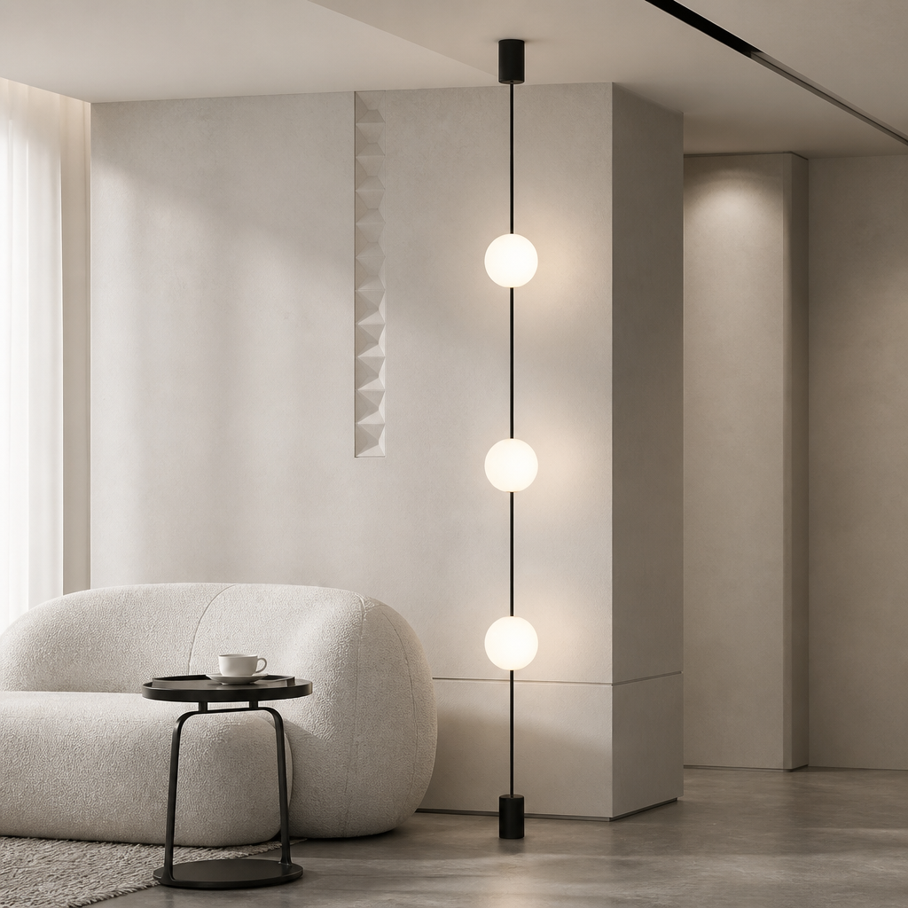 Contemporary lounge space with 3-head floor-to-ceiling LED globe light next to a rounded white armchair