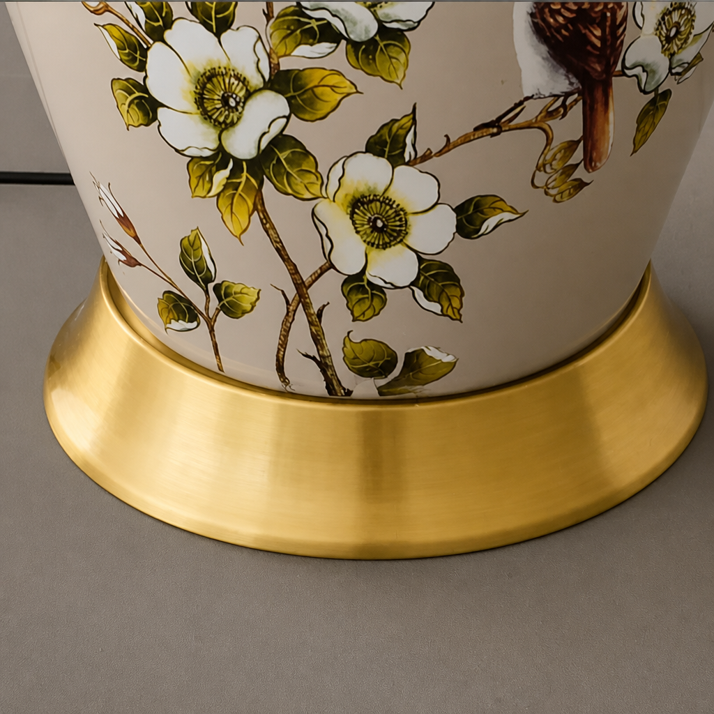 Decorative lamp base with floral design and gold base on a gray background
