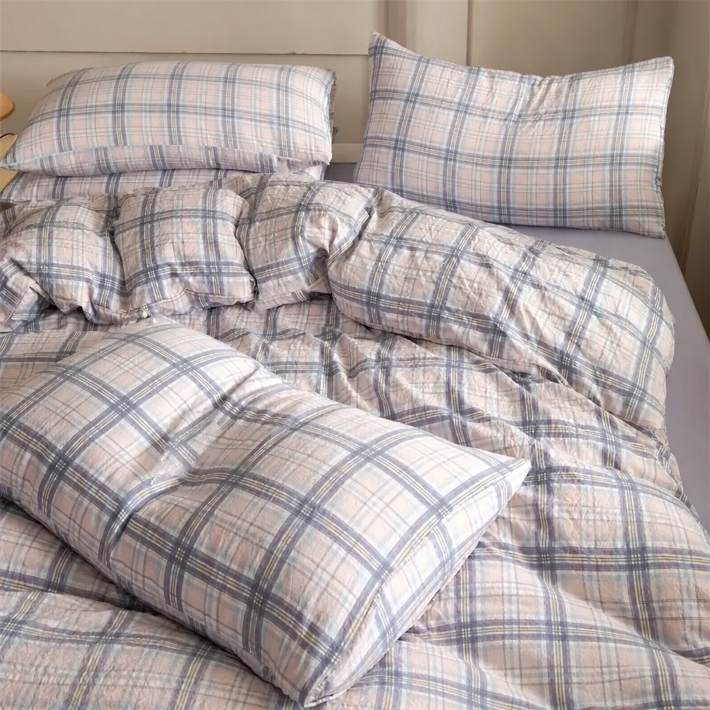 Plaid bedding set on a bed with pillows and comforter.
