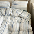Blue striped cotton bedding set styled with a book