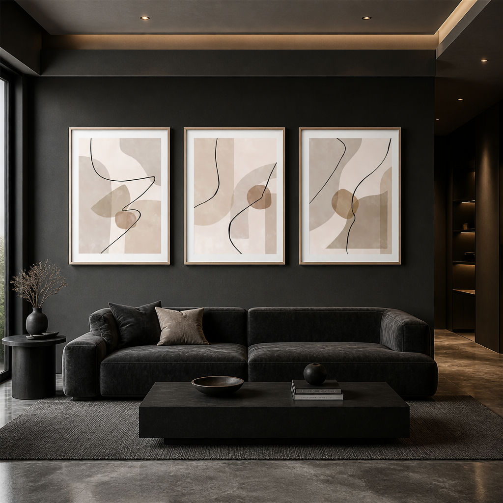 A modern living room with a dark charcoal sofa, black coffee table, and a dark charcoal wall featuring three framed abstract art prints in beige, taupe, and black.