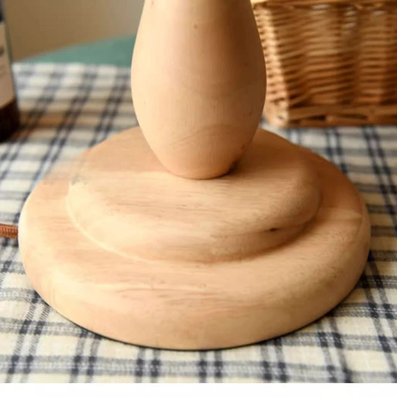 Close-up of a round wooden lamp base with a smooth natural finish