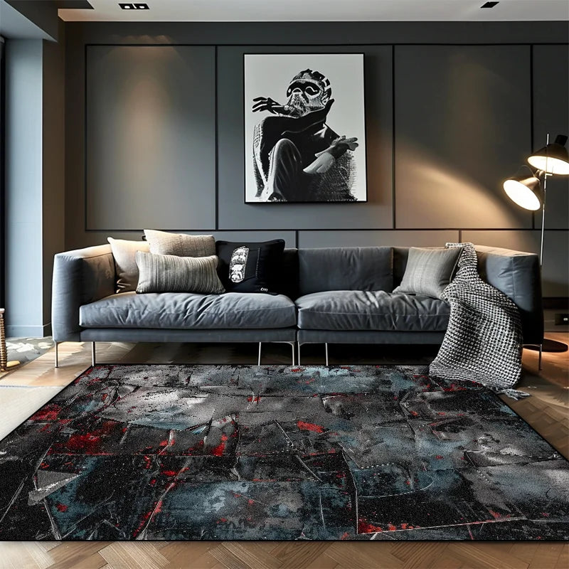 Large dark slate abstract area rug with red and blue paint splatter detail in a moody modern living room with grey sofa