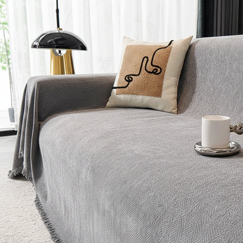 Slate Grey heavyweight sofa throw draped over a minimalist couch with a white coffee mug.