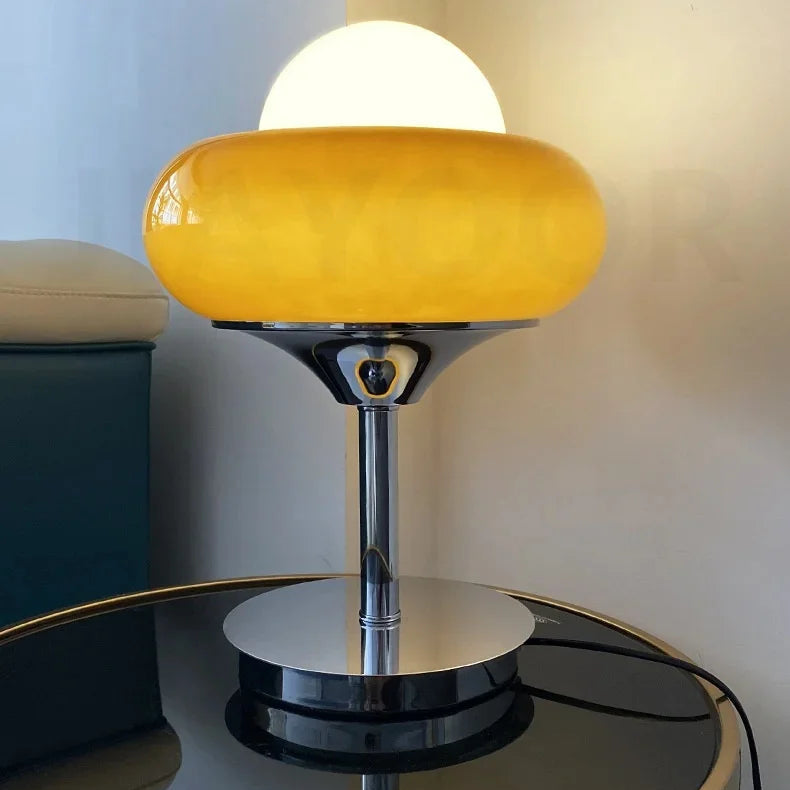 Yellow table lamp on a reflective surface with a neutral background