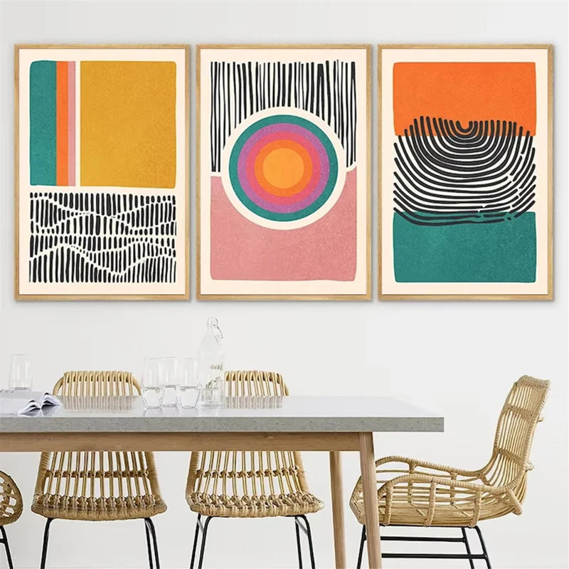 Framed abstract canvas set styled above a dining table with rattan chairs