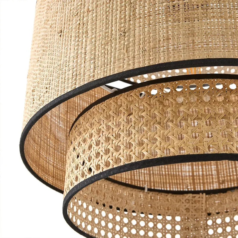 Close-up of a woven lampshade with black trim on a white background