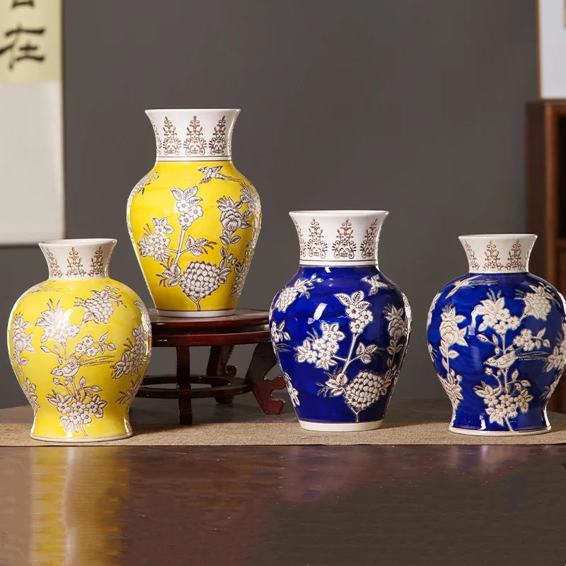 Set of four ceramic vases in yellow and blue with floral patterns on a dark background.