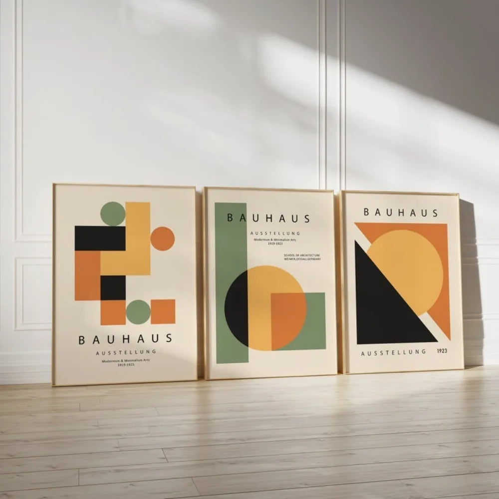 A curated 3-piece Bauhaus canvas art collection featuring geometric circles and blocks in sage green and ochre, leaning against a minimalist white wall.