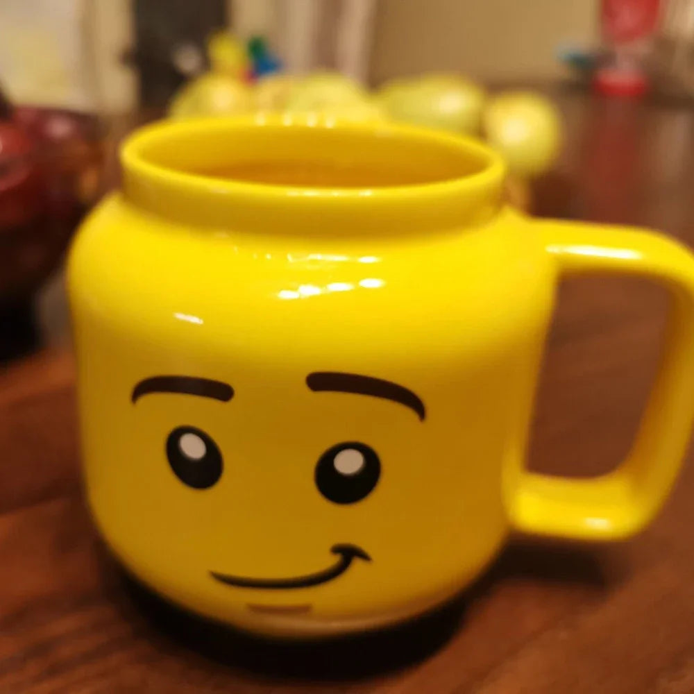 Yellow mug with a face design on a wooden surface