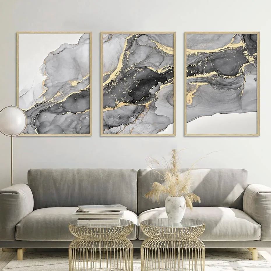 Three-piece abstract wall art set with soft grey marble effect and gold accents in a modern living room