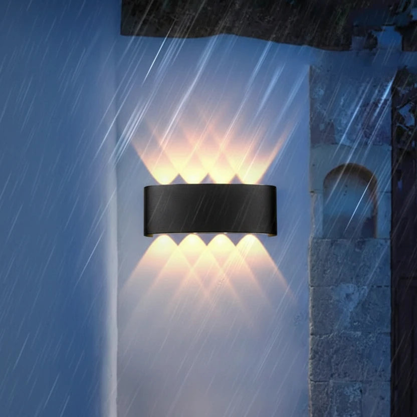 Modern black wall lamp casting geometric warm light beams on a wall