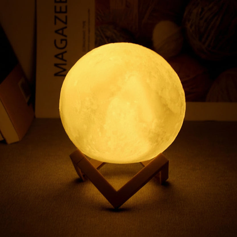 Moon night light emitting a warm glow on a stand in a dimly lit room.
