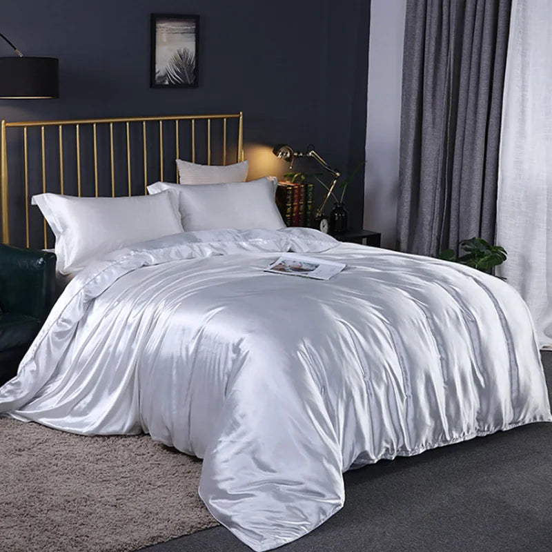 A Pearl White satin comforter on a bed in a bedroom setting
