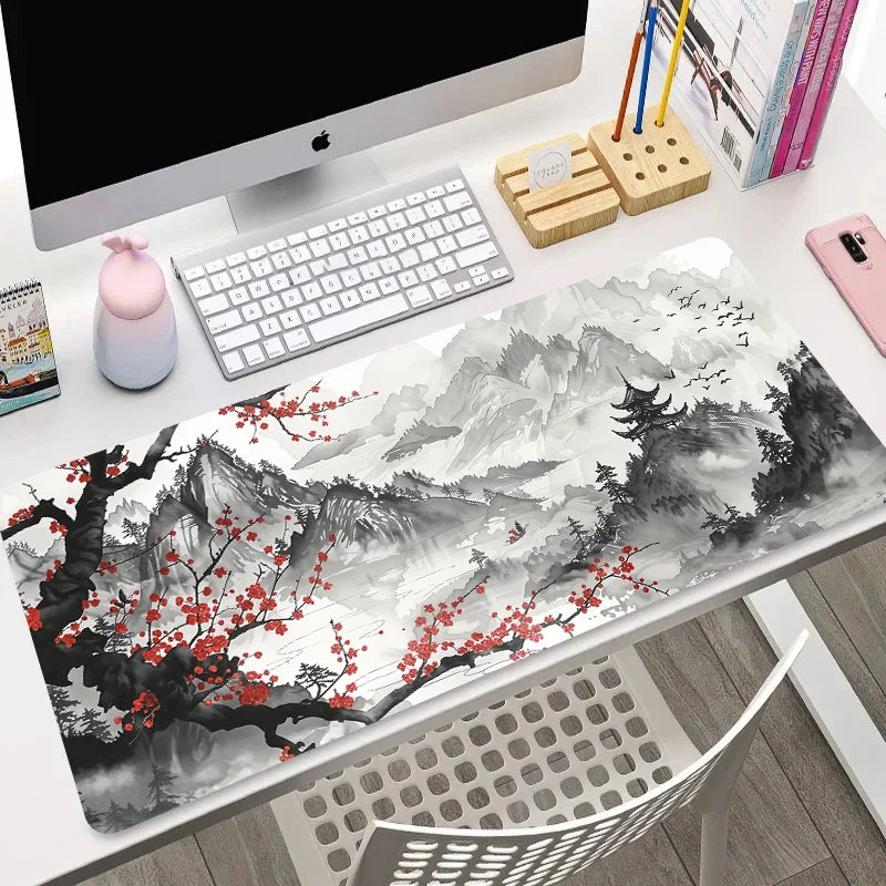 XL mouse pad with ink wash mountain landscape, red blossom branches, and flying birds, shown flat and rolled