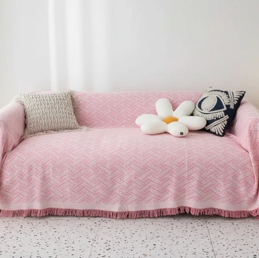 Blush pink coral fleece couch cover with fringe edging and soft decorative styling