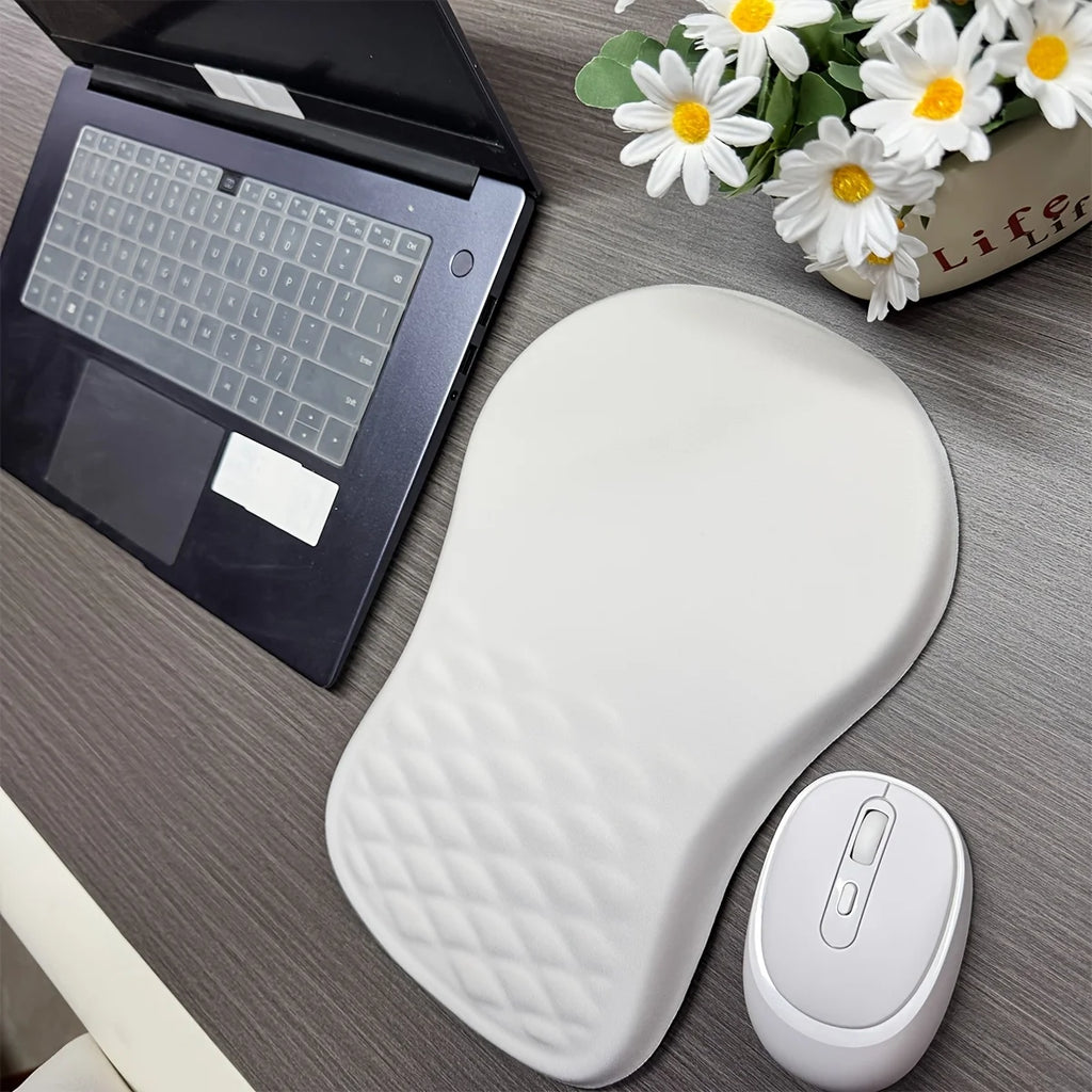 White wrist rest and mouse on a desk with a laptop and flowers in the background