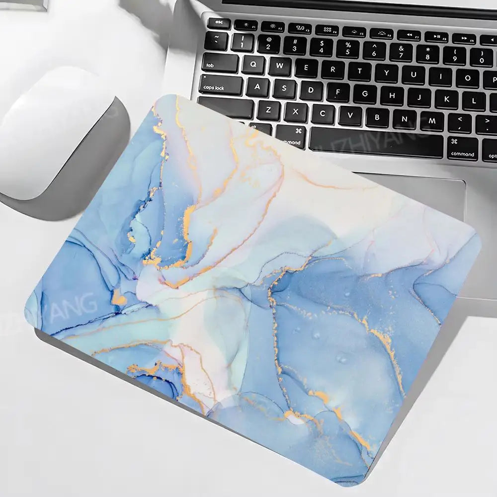 Marble-patterned mouse pad on a laptop with keyboard and mouse