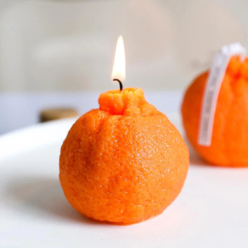 Candle made from an orange on a white surface with a blurred background